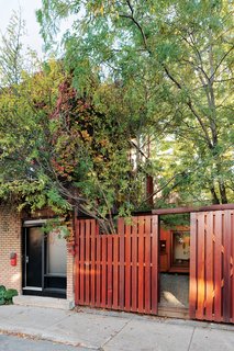 Sheltered behind the fence that runs along the sidewalk, the plantings give the courtyard the feeling of an urban oasis.