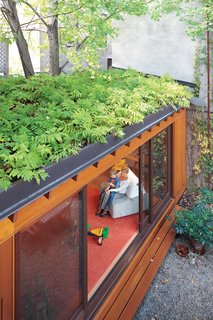 A small, single-story addition to the row house adds a playroom without eating up too much outdoor space. A green roof also helps makes up for lost garden beds, while creating attractive, leafy views from the second and third floors. In summer, when the sliding doors are left wide open, indoor and outdoor spaces blend together.