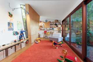One wall section in the playroom juts in to sidestep a mature tree outside, while slender windows allow the kids to monitor its progress through the seasons.