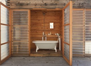 A Platform for Living - Photo 26 of 28 - The ultimate luxury: a hot bath in the clawfoot tub, with the fiberglass door open wide to the woods.