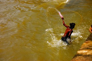 Touring India - Photo 21 of 27 - During the festival of Holi, Mumbai's inhabitants take to the streets and paint each other. This kid had enough and jumped in the harbor to wash himself clean.
