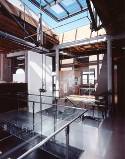 Located in the historic Washington Shoe Building in the Pioneer Square Historic District, the office design limits its impact on the preexisting space. The open plan layout is pulled away from the perimeter walls to limit contact with the existing historic structure and to take advantage of better natural daylight, circulation paths through the office, and to avoid the favoritism associated with the "corner office." Sustainable ideas were explored through the natural ventilation strategy (skylight and open stair for a chimney effect), not painting the warehouse walls or even the old windows (left "as is"), using masonite for floors and walls (a highly recycled content material left unpainted), and unpainted steel. Photo by Benjamin Benschneider.