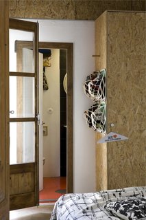 StuffBumps, the eco-friendly pop-up storage system that Scholtus designed with Graham Hill of the sustainability resource TreeHugger, hang on one side of a wardrobe constructed of oriented strand board (OSB), chosen because it contains minimal amounts of resin compared to other engineered woods.