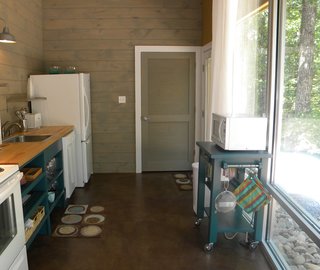 Sticking to a mostly natural-hued palette—save for the turquoise—the architect and builders chose stained concrete for the floor, tongue-and-groove pine for the walls, and an oak butcher block countertop from Ikea.