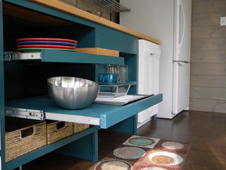 Made for easy reaching, these open pull-out shelves are in an ADA-compliant kitchen in a guesthouse designed by architecture firm Best & Associates. Although the shelves were designed without doors, they were painted inside and out with a turquoise paint for a uniform, finished look, and the sliding shelves mean that every inch can be accessed, even the very back of the shelves. 
