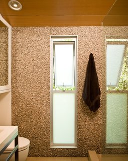 Though Jacobson initially wanted a completely open shower upstairs, Lee convinced him that a small lip would keep the splashes a bit more contained. The freestanding sink is from Canadian bath furnishings company Wetstyle.