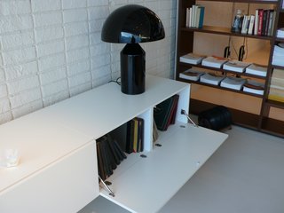 A low storage unit holds boxed LPs and an Atollo lamp by Oluce.