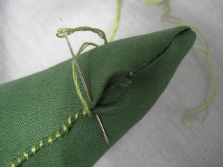 When he feels the right fluffiness, stitch the opening up with the green embroidery thread.