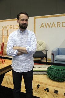 Designing the Modern World Award - Photo 1 of 2 - Dwell's Kyle Blue in front of the Modern World Awards exhibit at Dwell on Design.
