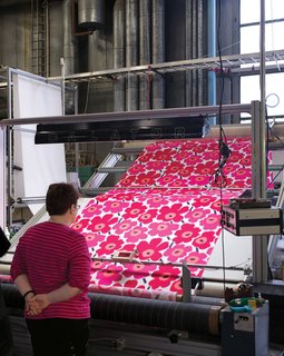 Here, another inspector checks a length of Pieni Unikko fabric.