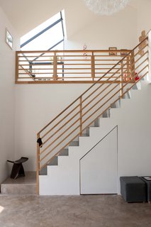 The spatial drama on the interior comes from the staircase and tatami room upstairs. The daffodil pendant overlooking it all is from Ikea. The butterfly stool is by Sori Yanagi and was a birthday present from Konishi to Gaffney.