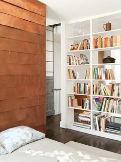 The copper-covered volume proceeds to the second floor, where it forms a storage wall in Sherman’s home office.