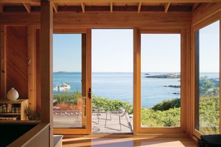 Take it Outside With These 11 Spring-Friendly Deck Spaces - Photo 8 of 11 - The porch at writer Bruce Porter's off-the-grid retreat on Ragged Island, Maine, boasts Leaf chairs by Arper, as well as dreamy views.