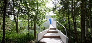 This Lake House Is a Living Piece of Architecture History - Photo 15 of 21 - The view from the driveway highlights the bright-blue entrance doorway.