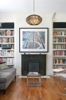 The living room in the original house has Victorian details, but the furniture—vintage Bertoia chairs, a Gloss floor lamp by Pablo Pardo, and a Norm 03 Steel Pendant Lamp by Normann Copenhagen—brings the look up to date.