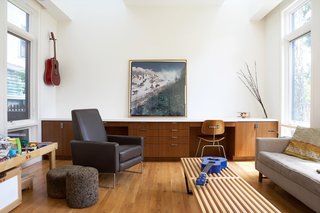 The family room has wall-to-wall cabinets built by Bradford T. Newhall Construction, a local company that also served as the general contractor on the project. The stainless steel drawer pulls are by Sugatsune. The minimalist white-and-wood interior complements the couple's collection of mod furniture, which includes a vintage sofa by Edward Wormley for Dunbar and two cork tables by Jasper Morrison for Moooi.