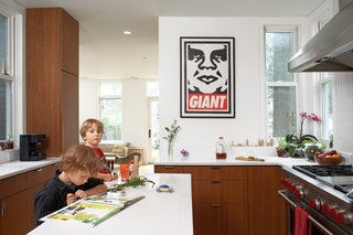 The cherry veneer cabinets carry into the streamlined kitchen where a Shepard Fairey print and a range by Wolf take pride of place. "We tried to make sure that all the wood used in the project looked seamless and uniform," says de Leon. "Wood was the only 'color' we introduced."