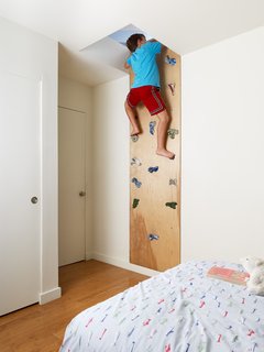 Feldman designed to roof to have a slope optimal for solar panels. An added benefit is the "secret" playspace above the kids's rooms. To access the space, Feldman created this cork wall with climbing pulls purchased from a local sporting goods store.