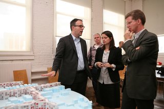 U.S. Secretary of Housing and Urban Development Shaun Donovan (right) discusses MOS's proposal with Michael Merideth and Hilary Sample.