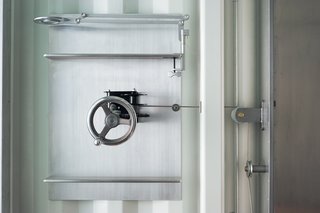 The Murphy bed is raised and lowered by a a hand-cranked wheel and pulley.