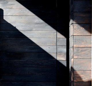 An example of black washed cedar siding similar to the finish that we will use. The imperfect application of the wash is intentional.