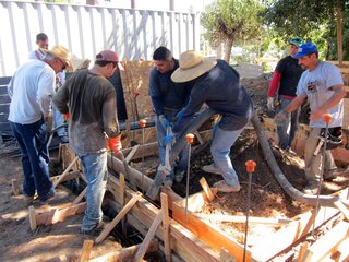 Concrete crew members work together during the pour as the hose is cumbersome to manage.