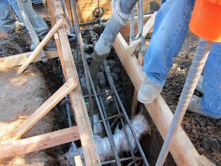 A tree root wrapped in mud, burlap and plastic is about to be encased in concrete.