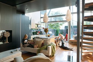 Koura pendant lights by New Zealand designer David Trubridge hang above the dining area. Their organic forms and diamond-shaped shadows create intimacy in the vast space. Among Bilardo’s contributions were the black tulipwood cabinetry and ceiling and the cantilevered concrete countertop that appears to go through the glass wall.