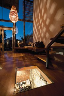 Inspired by a local winery, Kyprianou wanted a glass top on his subterranean wine cellar. The interior is lit, casting soft light into the living space at night and revealing the 132-year-old stone foundation. The three-quarter-inch glass lid sits flush with the floorboards; it opens with an ingenious device that Kyprianou devised using a 12-volt air compressor and a remote-controlled switch. When you push the button, the glass lifts just enough to be removed by hand.