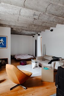 A Little Apartment Gets a Solid Renovation - Photo 3 of 8 - The rest of Kordík's small apartment is given over to an open-plan living and bedroom. The waves of the concrete ceiling offer a bit of overhead character while lounging on the couch or in bed.