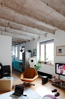 A Little Apartment Gets a Solid Renovation - Photo 7 of 8 - Here's a view from the bedroom toward the kitchen. Kordík knocked down a series of walls to open the space, but considerable light from the street and the clean white brick also help give it an expansive feel.