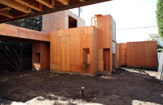 Looking west from the living room across the main courtyard to the master bedroom and garage beyond. The connecting bridge in the left of the photo will cover a dining pavilion underneath.