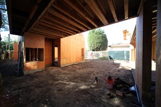 The roof of the outdoor dining pavilion in the main courtyard is also a footbridge connecting two portions of the house above. The box opening on the left will house one of the two outdoor fireplaces by Spark Modern Fires.