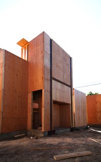 This tall structure holds an external staircase leading up to a rooftop garden and media studio. The square opening underneath will house an outdoor fireplace by Spark Modern Fires. The tall opening left of that is a storage cabinet.