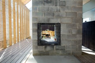 Their deck has a concrete block fireplace and antique wooden furniture.