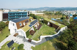 Big Man on CampusBuilt on Kolon Engineering and Construction's grounds, the E+ Home is the neighborhood's green building star. From this angle you can see the permeable pavers and sustainable landscaping, like water catchment pools and living walls, that make this place a paragon of green housing.
