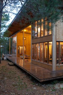 A view of the exterior of the structure, showing the two families' separate living spaces anchored by a single broad porch.