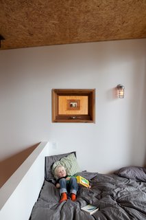 As shown here, the orientation of the two houses provides both privacy and occasional moments of permeability; a peek through the window above the master bed reveals neighbors across the way.