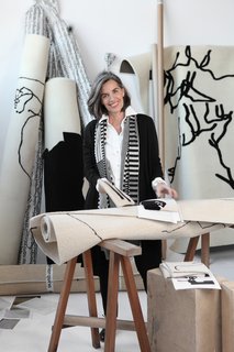 Nani Marquina stands in front of her latest line of rugs, Chillida, a reinterpretation of artist Eduardo Chillida's work, released in 2012 at the Salone Internazionale del Mobile.