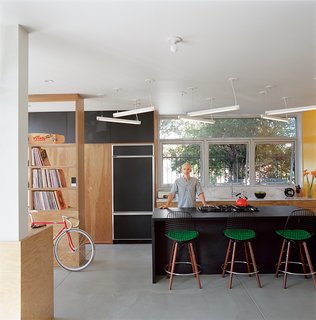 Riffing on the Los Angeles phenomenon of people "murdering out" their cars—that is, removing all the trim and blacking everything out—architect Barbara Bestor and craftsman Eric Lamers covered most surfaces in this Los Angeles kitchen with matte black laminate, including the fridge and the overhead cabinets.