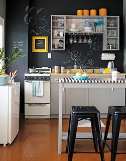 This kitchen manages to look playful and edgy with chalkboard paint: the matte black is crisp, but the scribbles add whimsy. Reprinted from The First Apartment Book by Kyle Schuneman. Copyright © 2012. Published by Clarkson Potter, a division of Random House, Inc.