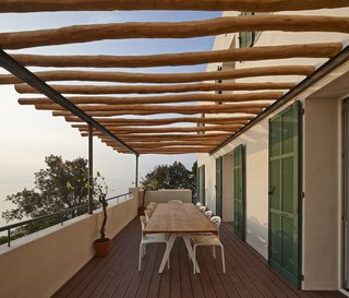 A Renovated Modernist Oasis in the French Riviera - Photo 7 of 9 - On the patio, robinia wood beams shade a Kettal Vieques dining table and set of Moroso Supernatural chairs.
