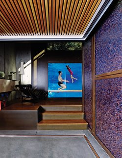 Spencer Greene and his daughter, Anya, go for a dip in their Palo Alto, California, home. The three-inch-thick acrylic pool window allows the parents to monitor their children’s swims from the LC4 chaise longue.