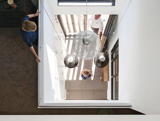 A Modern Take on the Pitched-Roof - Photo 3 of 12 - Inside, just off the entrance, pendant lights from Woonfabriek hang in the triple-height central hall.