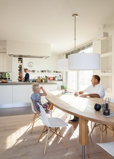A Modern Take on the Pitched-Roof - Photo 4 of 12 - The kitchen of a home on an Amsterdam canal "is where it all happens," says Van Zeijl. As the hub of the home, the room is situated at the front of the house and features a minimal palette and Belgian granite countertops. The table is by Pilat & Pilat and the pendants are from It’s About Romi.