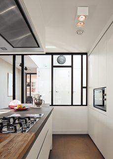 A Modern Take on the Pitched-Roof - Photo 5 of 12 - With a custom design by Scalo, the kitchen is "white and simple; we didn’t want handles," notes De Graaf. The hotplate, oven, and teppan-yaki grill are from Falliss.