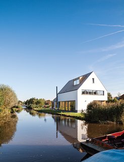 A Modern Take on the Pitched-Roof - Photo 8 of 12 - The newly built house, just feet from the water’s edge, occupies the space where a decaying farmhouse once stood.