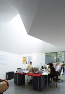 Victorian Home in London Gets a Modern Office Addition - Photo 3 of 7 - The couple's firm specializes in illustration and photography for the advertising industry. The framed art is by Anthony Burrill and the wall calendar is the work of Crispin Finn. The Ikea office table is ringed by Fritz Hansen Butterfly Chairs and Herman Miller Aeron Chairs. The lighting is by Artemide.