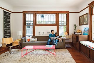 The home’s original living and dining rooms were updated with custom cabinetry and new fir floors. The living room sofa, coffee table, and lounge chair are from Blu Dot.