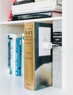The garage is an exercise in "hide and reveal." The Corian shelf features an outlet in a converted book, a detail that brings delight to a mundane task. "We wanted to make the experience of plugging in a phone or computer joyful," Grizzle says.